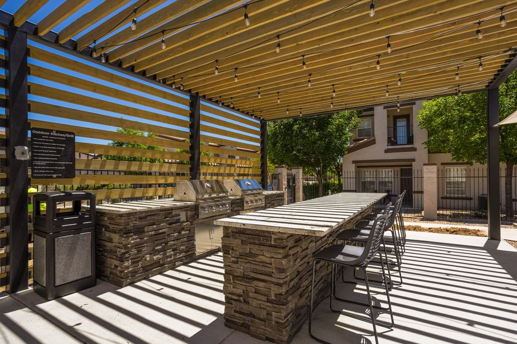 a patio with tables and chairs under a wooden roof